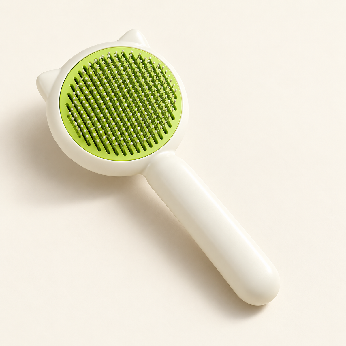 Cepillo marfil y verde con púas y botón de limpieza sobre fondo crema